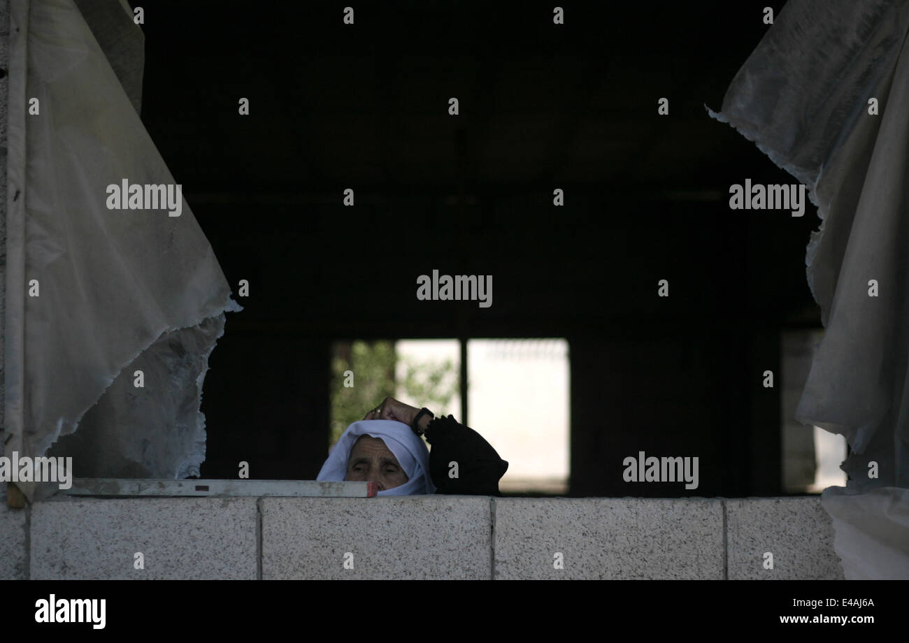 7. Juli 2014 - Rafah, Gaza-Streifen, Palästinensische Autonomiegebiete - eine Frau sieht auf den Körper der palästinensischen Hamas Militanten Abdulrahman al-Zameli während seiner Beerdigung in Rafah im südlichen Gazastreifen 7. Juli 2014. Israelische Luftangriffe getötet, sechs Hamas-Kämpfer, einer von ihnen al-Zameli, im Gaza-Streifen am Montag, die islamistische Gruppe sagte, in die tödlichsten Angriffe in eine Welle von Gewalt durch die Entführung und Tötung von drei israelischen Jugendlichen und einem palästinensischen Teen verschärft. Das israelische Militär sagte seine Flugzeuge gezielt '' Terror Websites und verdeckte Raketenwerfer '' in der Enklave. Er sagte etwa 10 roc Stockfoto