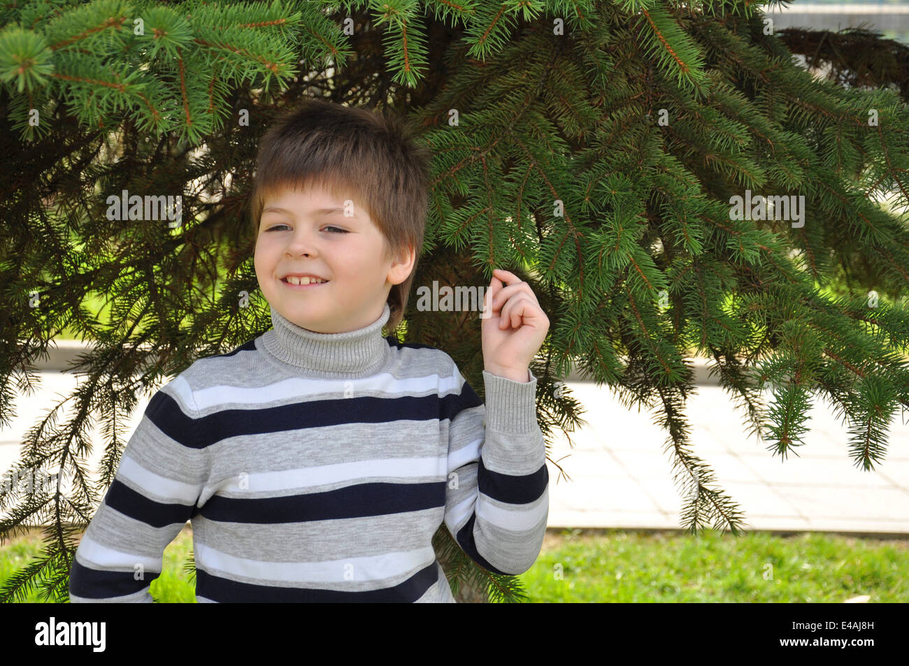 junge Kind Porträt einer achtjährigen Wert Rollkragen Strickjacke Pullover Streifen gestreift Parks Gärten grüne blondes Haar sieht Blick da Stockfoto