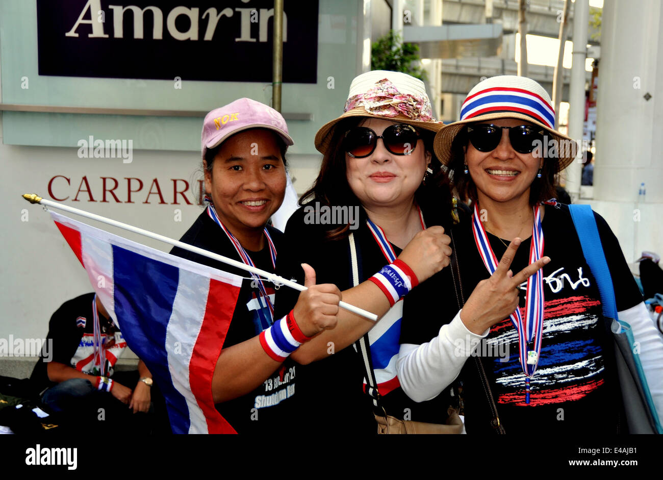 BANGKOK, THAILAND: Drei Frauen geschmückt mit roten, weißen und blauen Kleidung Regierung protestiert Stockfoto