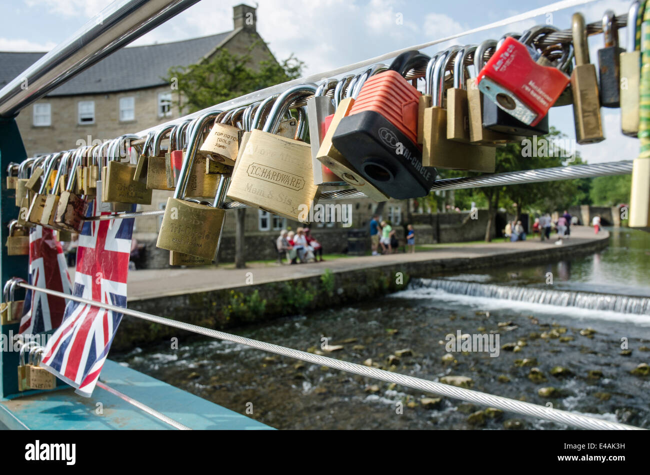 Beschriftete Vorhängeschlösser angebracht als Zeichen der Liebe, eine Fußgängerbrücke in Bakewell Derbyshire Stockfoto