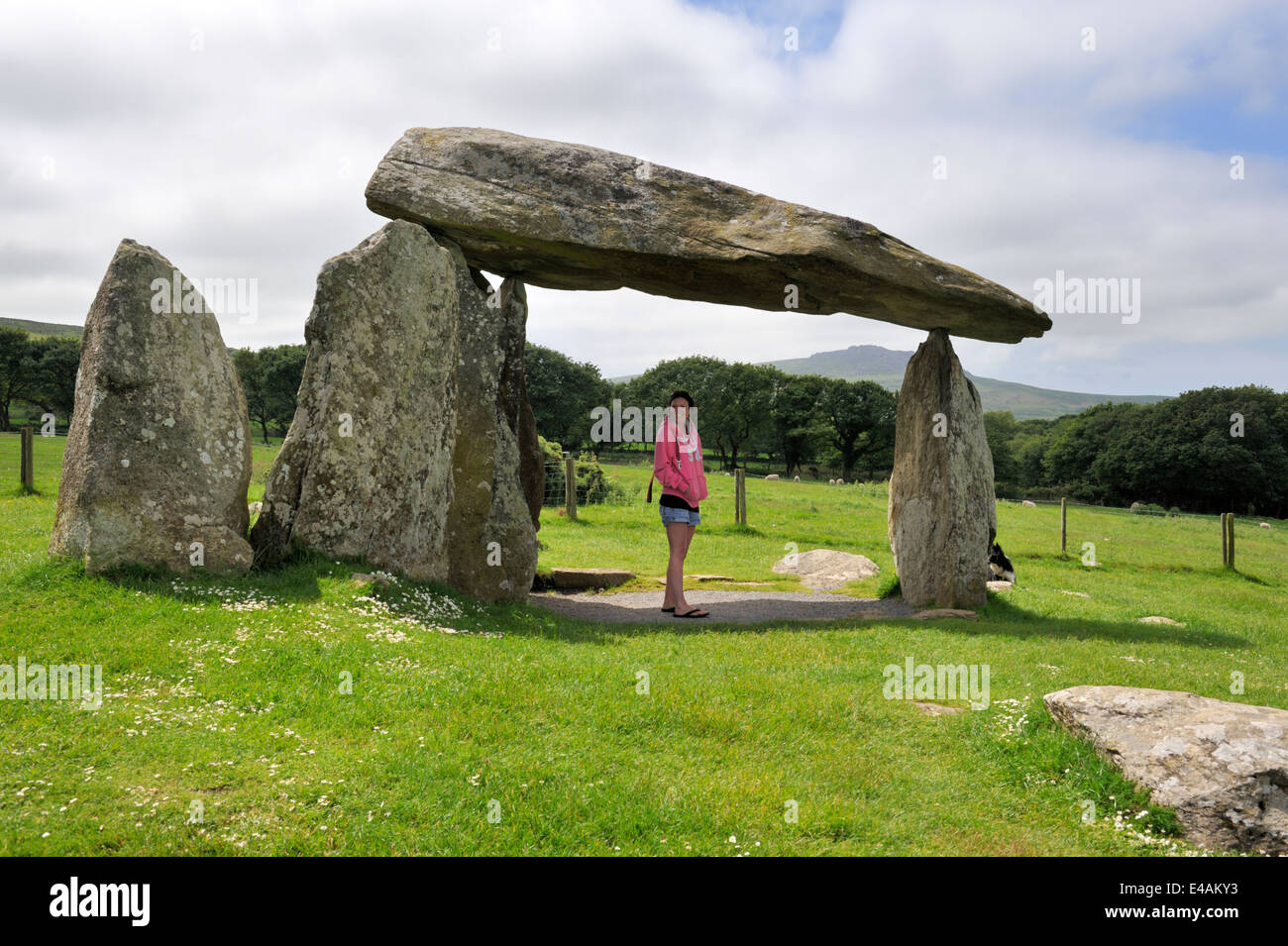 Frau stand unter der Pentre Ifan Grabkammer Schlussstein, West Pembrokeshire, Wales UK Stockfoto