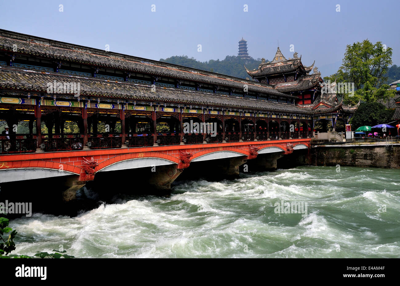 DUJIANGYAN, CHINA: Die Ming-Dynastie Nan Qiao gedeckte Holzbrücke über den Min-Fluss mit fernen Hügel Pagode Stockfoto