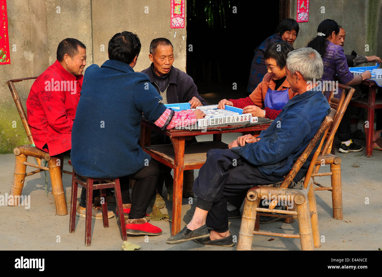 PENGZHOU, CHINA: Eine Gruppe von Freunden eine Partie Mahjong auf Bambus-Stühle vor einem Sichuan Provinz Bauernhaus sitzend Stockfoto