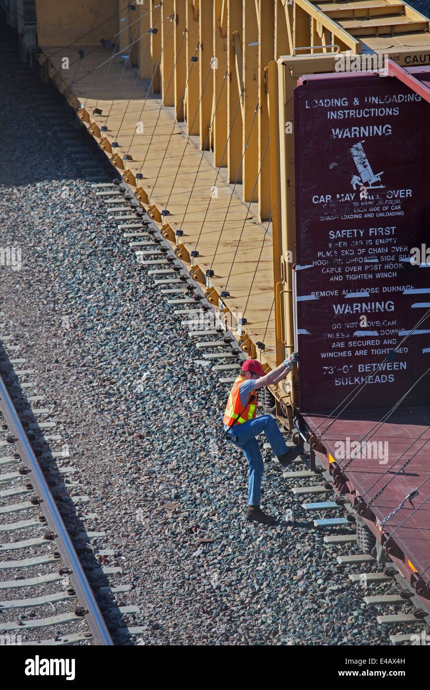 Newcastle, Wyoming - ein Arbeiter Platinen einen Güterzug auf der BNSF Railway Hof. Stockfoto