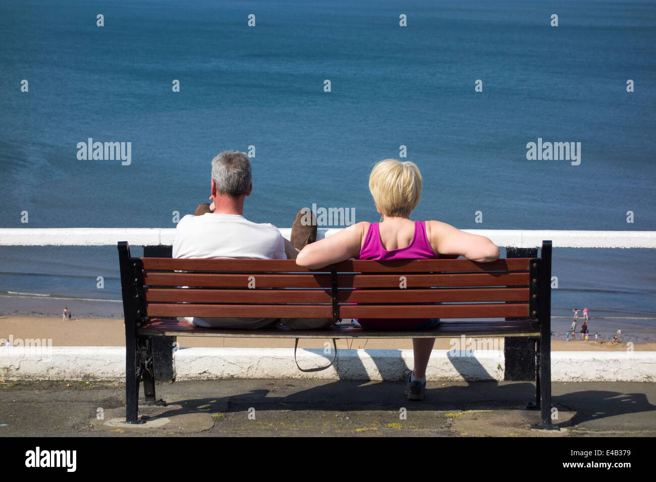 Älteres Paar auf Bank mit Blick auf Saltburn Strand sitzen. Saltburn von Meer, North Yorkshire, England, UK Stockfoto