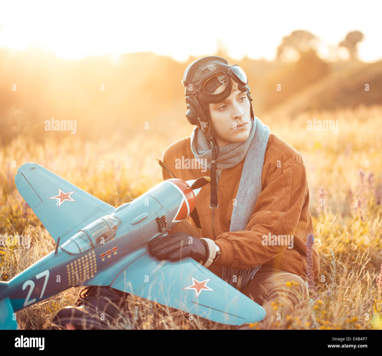 Junger Kerl in Vintage-Kleidung-Pilot mit einem Flugzeug Modell im freien Stockfoto