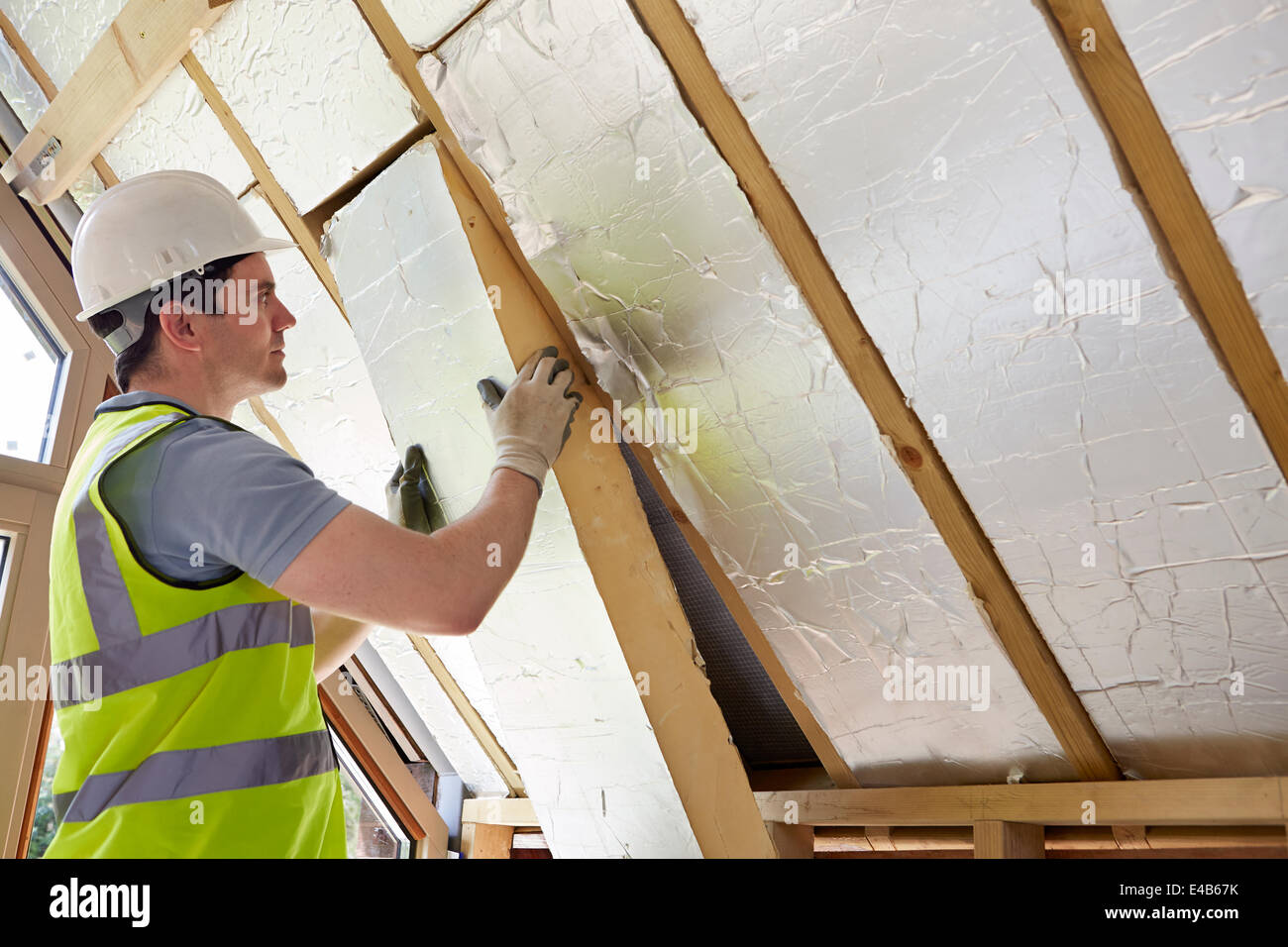 Baumeister, die Dämmung in Dach des neuen Hauses passend Stockfoto