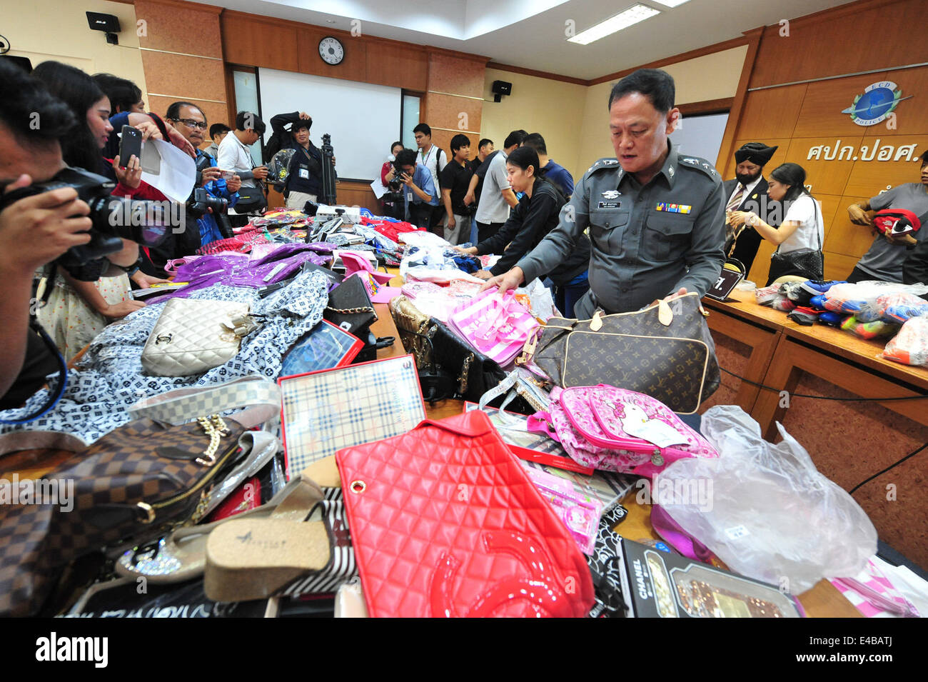Bangkok, Thailand. 8. Juli 2014. Ein Offizier zeigt beschlagnahmte gefälschte waren im Wert von 10 Millionen Thai Baht bei einer Pressekonferenz am Verbrechen Unterdrückung Wirtschaftsabteilung in Bangkok, Thailand, 8. Juli 2014. Bildnachweis: Rachen Sageamsak/Xinhua/Alamy Live-Nachrichten Stockfoto