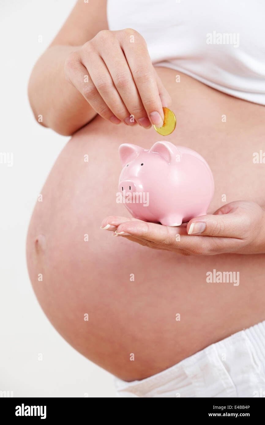 Nahaufnahme von Schwangeren, Münze ins Sparschwein Stockfoto