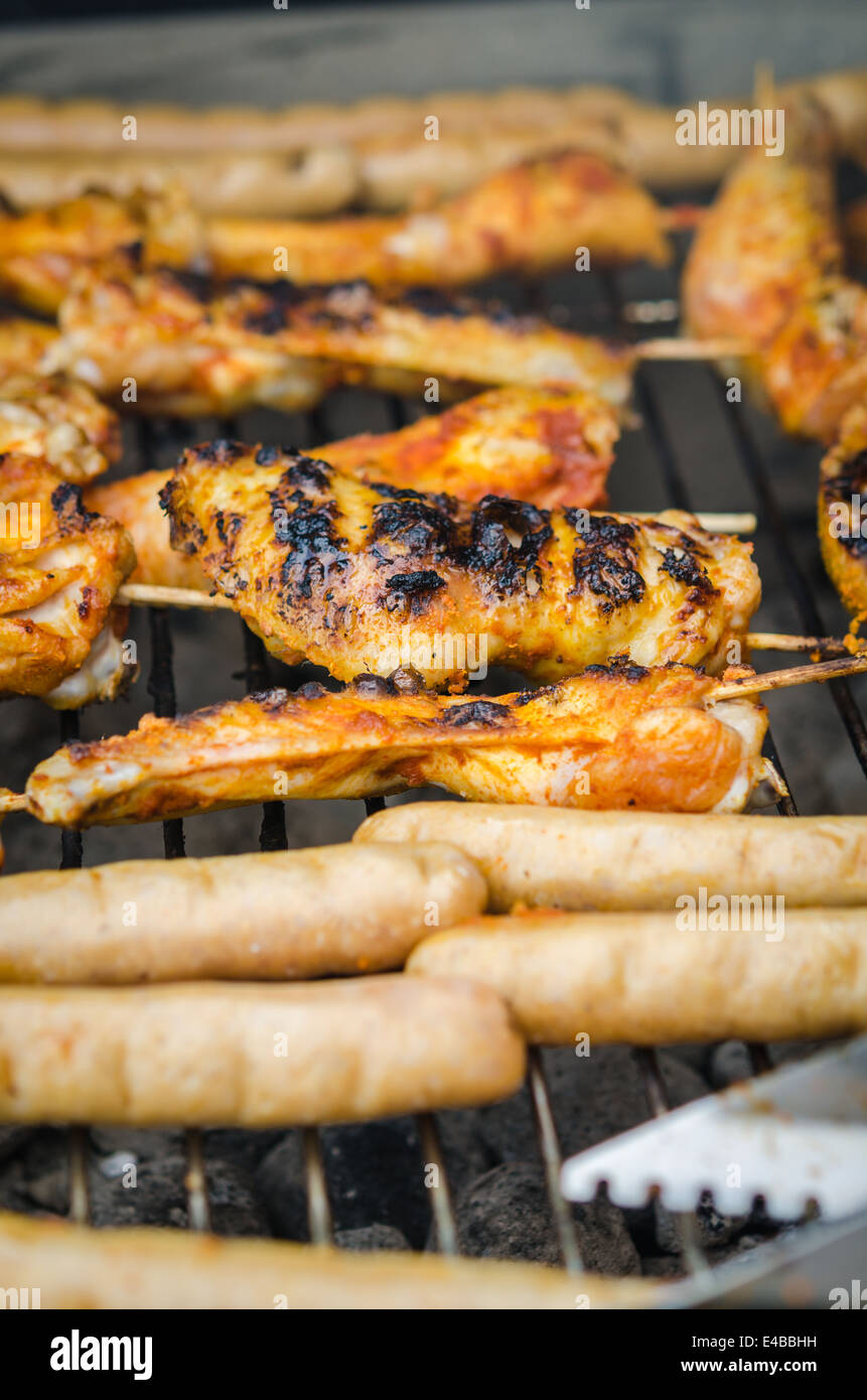 Würstchen und Chicken Wings auf das Rauchen grill barbeque Stockfoto