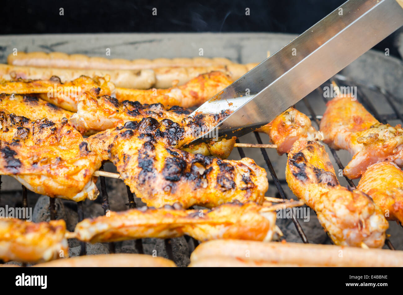 Würstchen und Chicken Wings auf das Rauchen grill barbeque Stockfoto