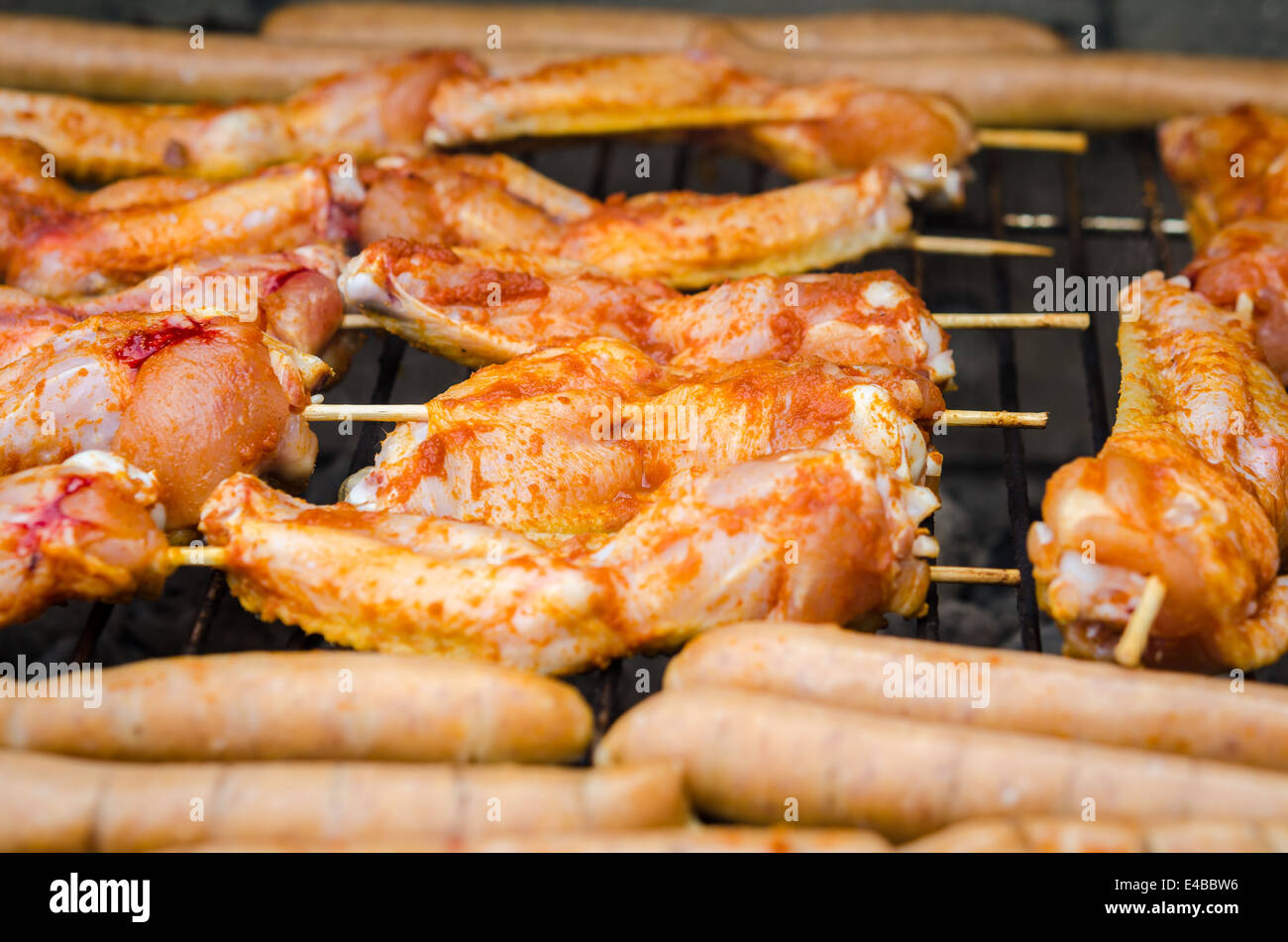 Würstchen und Chicken Wings auf das Rauchen grill barbeque Stockfoto
