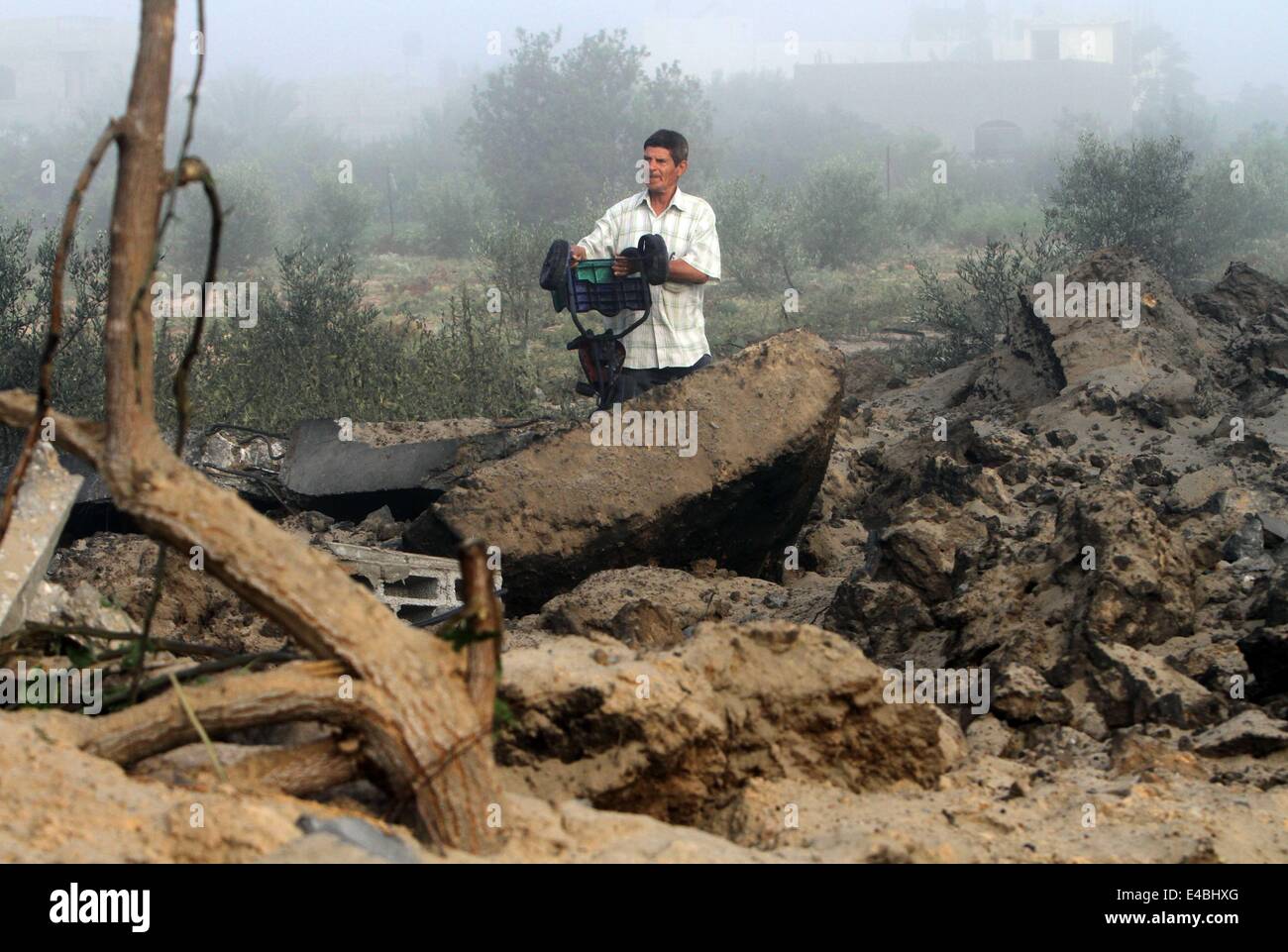 16. April 2010 - Khan Younis, Gaza-Streifen wurde Palästina - A palästinensischen Mann sein Haus prüft die Polizei sagte, bei einem israelischen Luftangriff in Khan Younis im südlichen Gazastreifen 8. Juli 2014 zerstört. Israel startete eine Offensive gegen die islamistische Hamas im Gaza-Streifen am Dienstag einige 50 Ziele, darunter Wohnhäuser, in einer Kampagne, die palästinensischen Raketenbeschuss auf den jüdischen Staat zu beenden soll. Das israelische Militär sagte, dass es rund 50 Standorten in Luft- und Seestreitkräfte Angriffe gezielt. Palästinensische Beamte sagten, mehr als 30 davon in etwas mehr als einer Stunde vor der Morgendämmerung, im bombardiert wurden Stockfoto