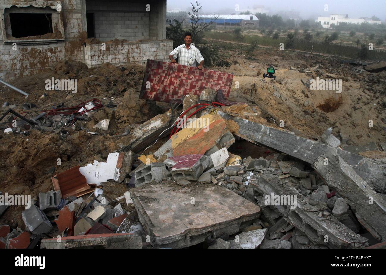 16. April 2010 - Khan Younis, Gaza-Streifen wurde Palästina - A palästinensischen Mann sein Haus prüft die Polizei sagte, bei einem israelischen Luftangriff in Khan Younis im südlichen Gazastreifen 8. Juli 2014 zerstört. Israel startete eine Offensive gegen die islamistische Hamas im Gaza-Streifen am Dienstag einige 50 Ziele, darunter Wohnhäuser, in einer Kampagne, die palästinensischen Raketenbeschuss auf den jüdischen Staat zu beenden soll. Das israelische Militär sagte, dass es rund 50 Standorten in Luft- und Seestreitkräfte Angriffe gezielt. Palästinensische Beamte sagten, mehr als 30 davon in etwas mehr als einer Stunde vor der Morgendämmerung, im bombardiert wurden Stockfoto