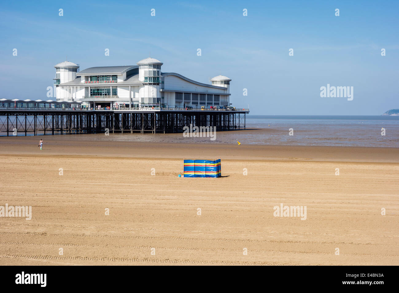 Windschutz und eine Person am Strand von Weston-super-Mare, Somerset, Großbritannien Stockfoto