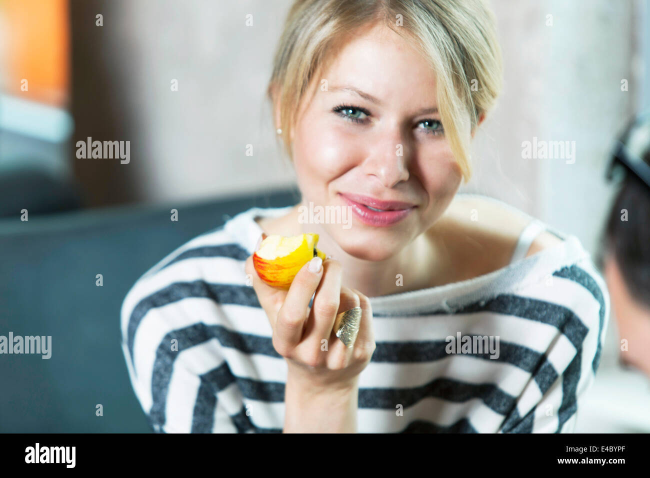 Frau mit blonden Haaren einen Apfel essen Stockfoto