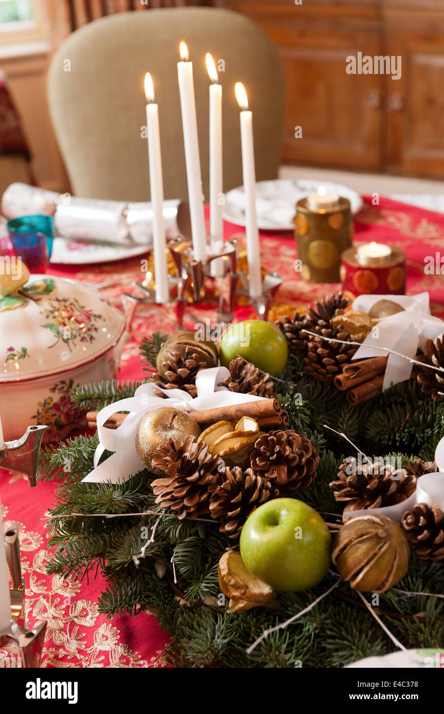 Detail von einem Chirstmas Wrather auf einen Tisch gelegt für das Weihnachtsessen mit Kerzen und Dekorationen. Das Geschirr ist eine Mischung aus Schulmuseum Stockfoto