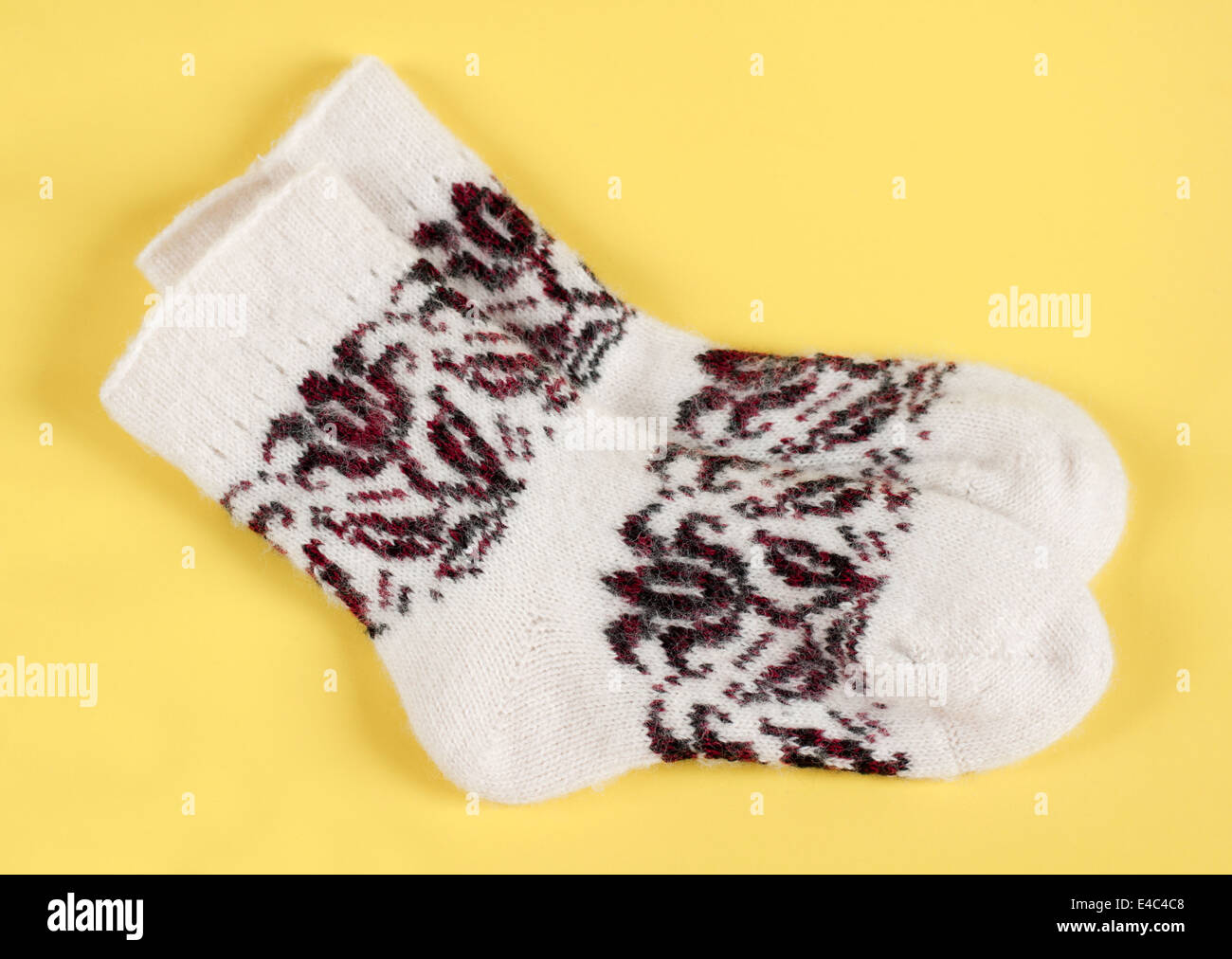 Socken gestrickt aus Wolle Wolle warm weiße Muster Ornament Kleidung Handarbeiten stricken. Hintergrund gelb niemand winter Stockfoto