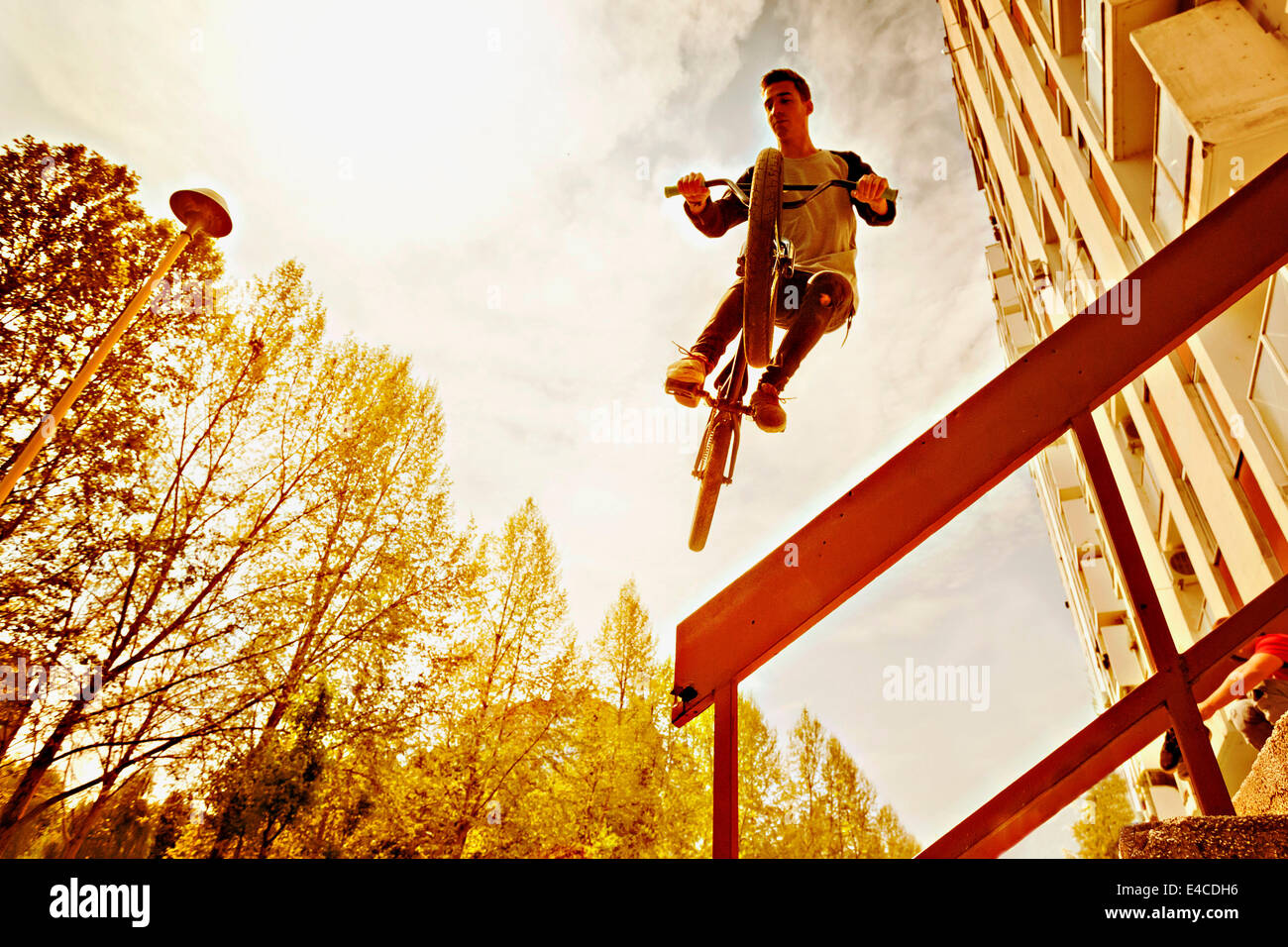 BMX-Biker bei einem Stunt über ein Geländer Stockfoto