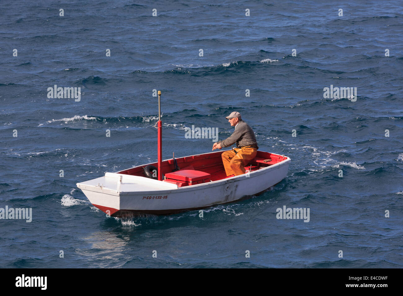 Getaria, Gipuzkoa, Baskisches Land, Spanien. Ein einheimischer Fischer in einem kleinen Boot trotzt die raue See. Stockfoto