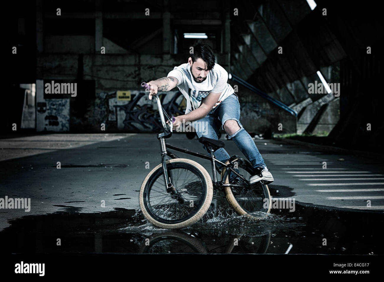 BMX-Biker einen Stunt auf einer Pfütze durchführen Stockfoto