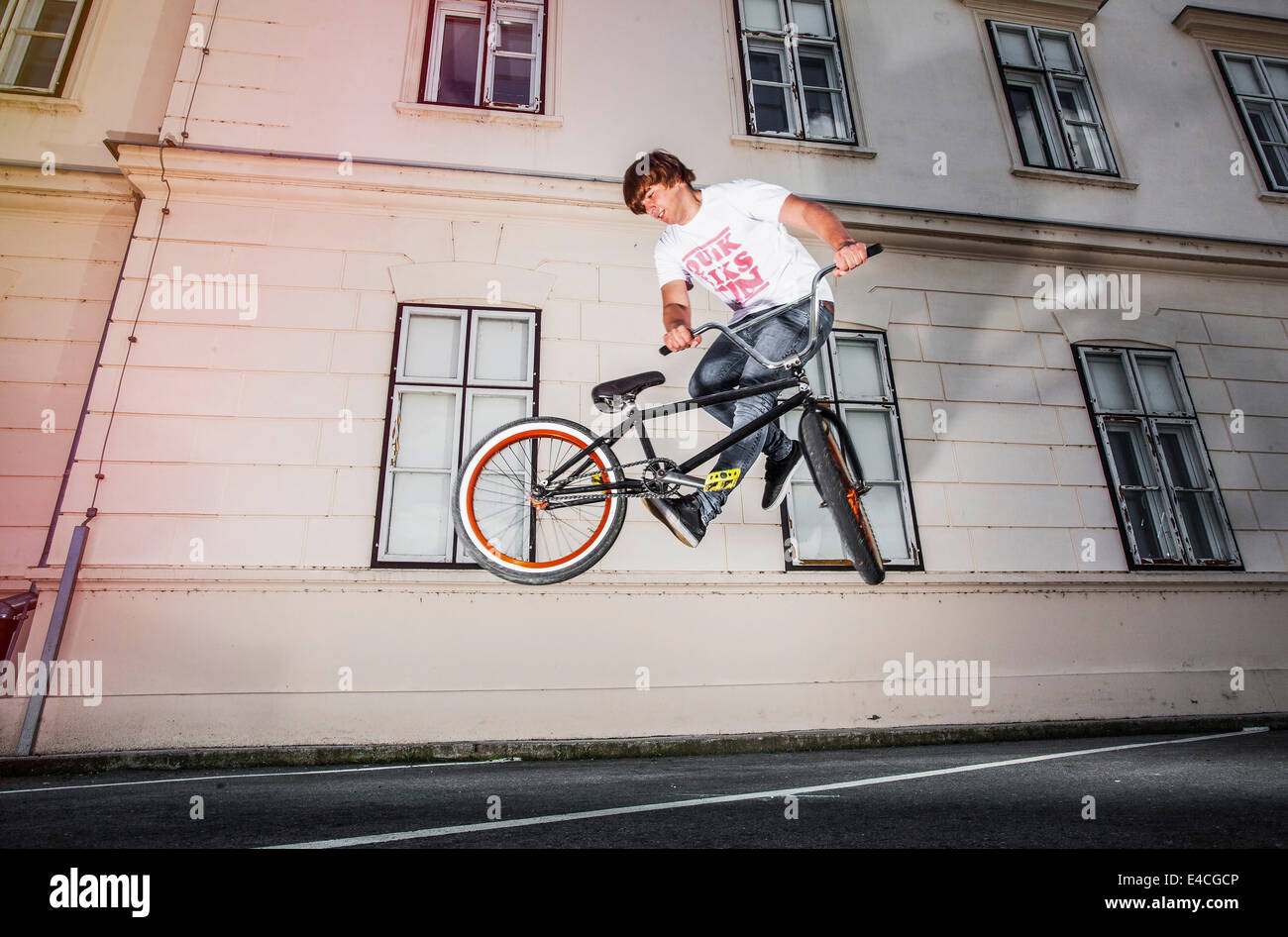 BMX-Biker einen Stunt vor einem Haus durchführen Stockfoto