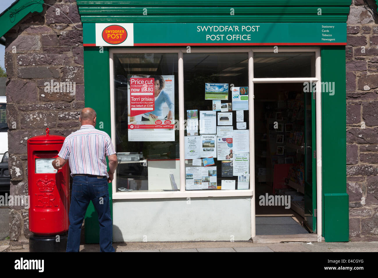Mann Entsendung Brief außerhalb der Post, St Davids, Pembrokeshire Stockfoto
