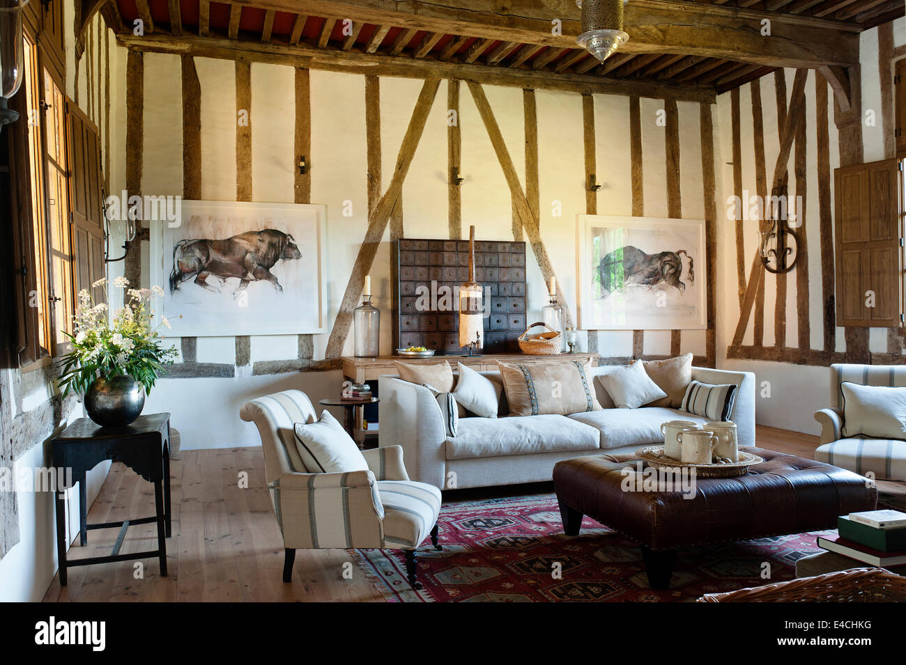 Geknöpfte osmanischen neutral getönten Ledersofa im großen Salon mit Holz gerahmt Wände. Die große Aquarelle sind von Mark Stockfoto