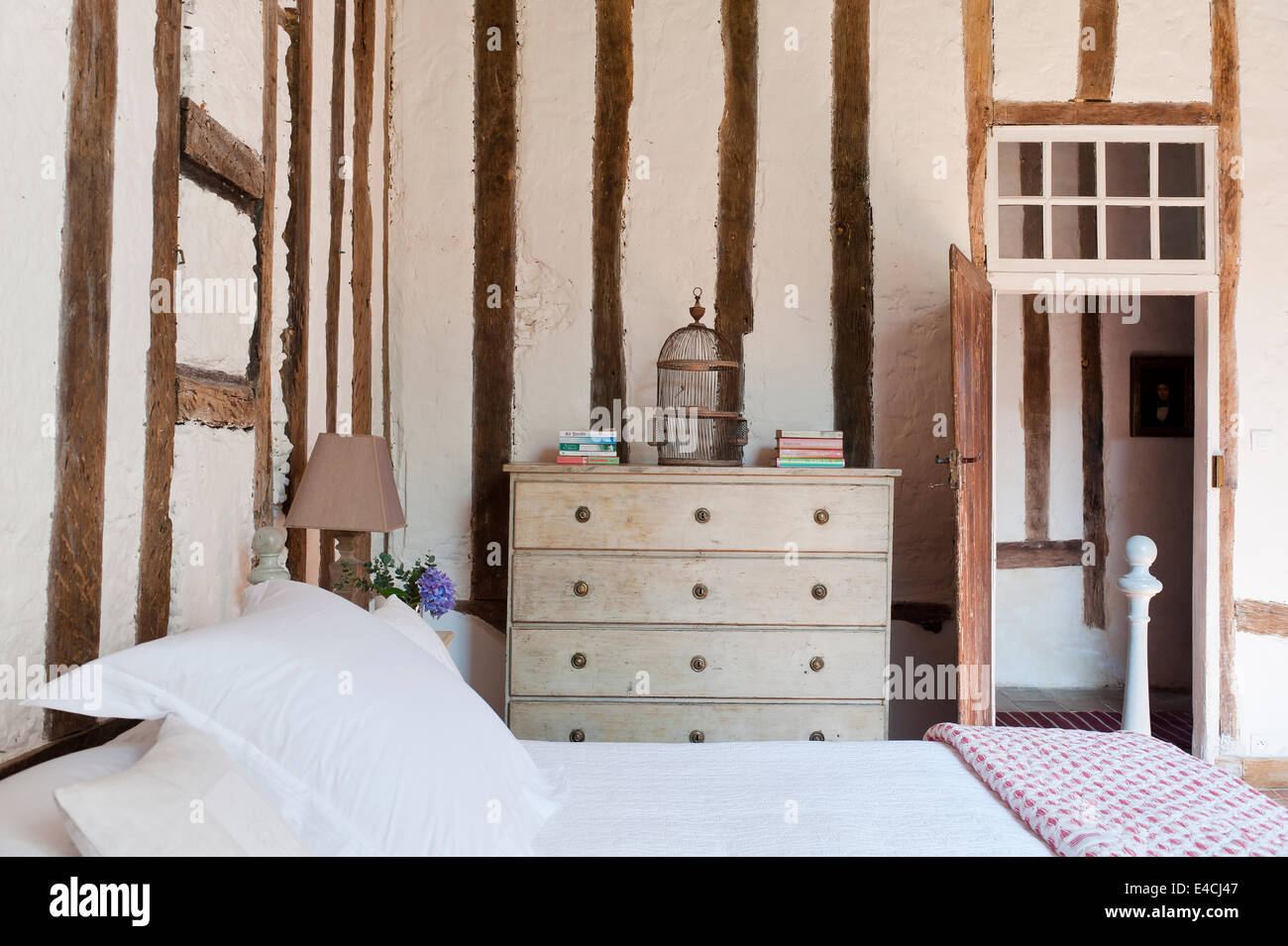 Fachwerk Wände mit gerenderten Füllung im Schlafzimmer mit Kommode und alten Vogelkäfig Stockfoto
