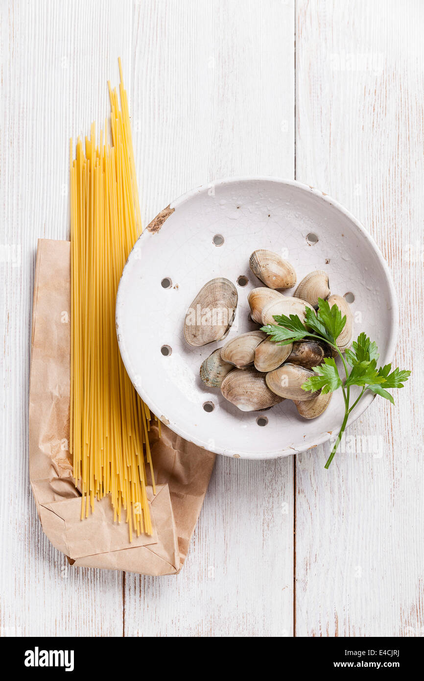 Rohe Oberteile Vongole und rohe Sapaghetti zum Kochen Pasta Vongole auf weißem Holz Hintergrund Stockfoto