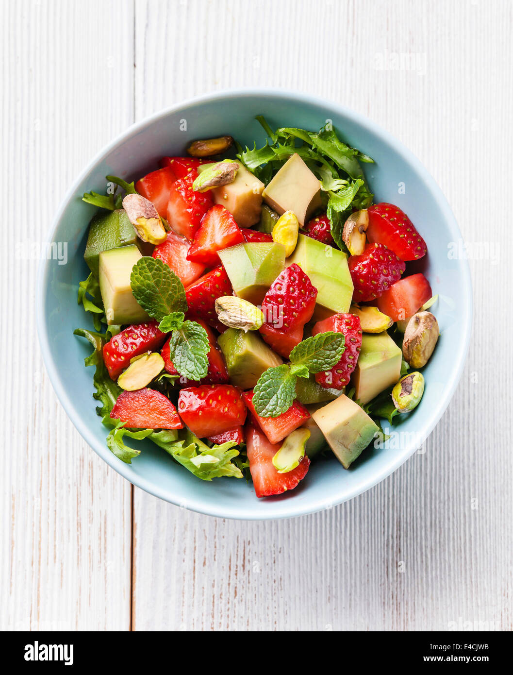 Blattsalat mit Avocado und Erdbeere in blau Schüssel Stockfoto