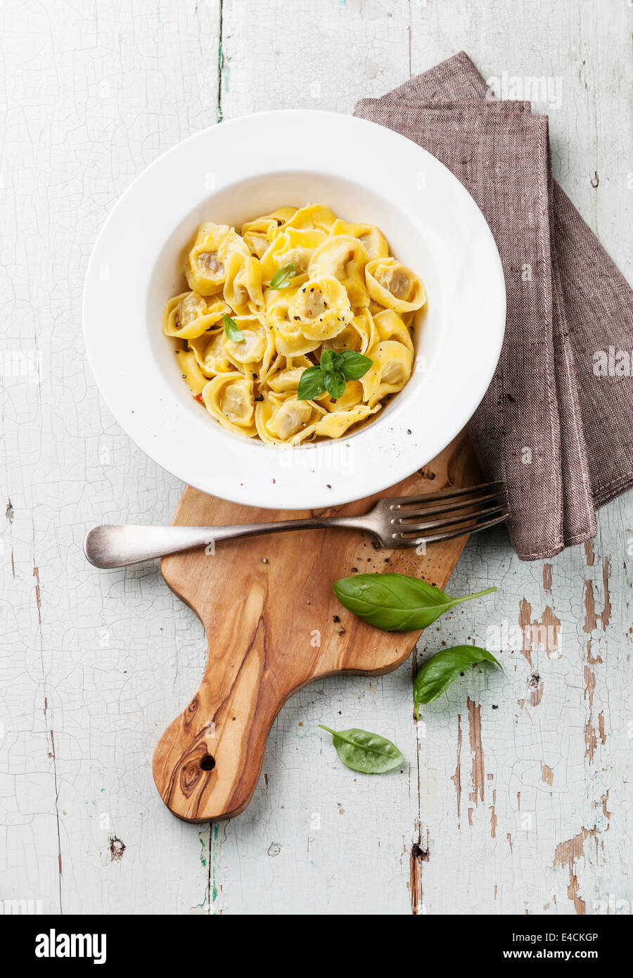 Tortelli Tortellini mit Fleisch hausgemachten in weiße Schüssel auf Oliven Holz Schneidebrett Stockfoto
