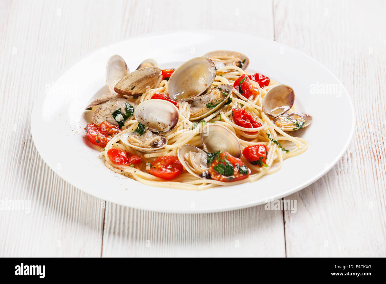 Pasta mit Meeresfrüchten mit Muscheln in Tomatensauce Spaghetti Alle Vongole auf weißem Holz Hintergrund Stockfoto
