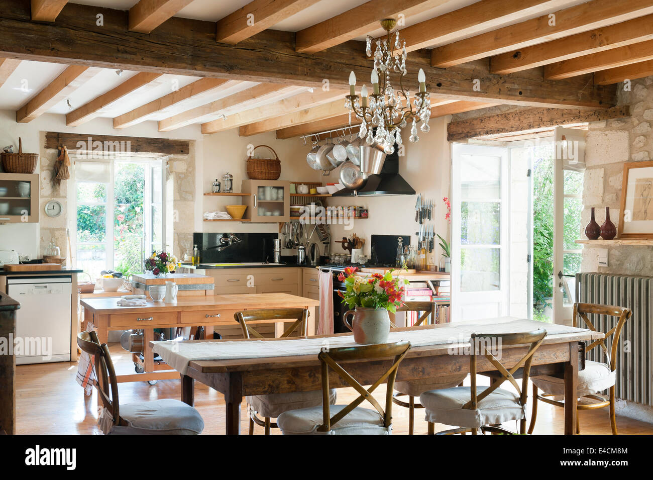 Rustikale Küche mit französischer Esstisch aus Holz, decken-Balken, Glas-Kronleuchter und traditionellen Camargue-Stil Speisen Stockfoto