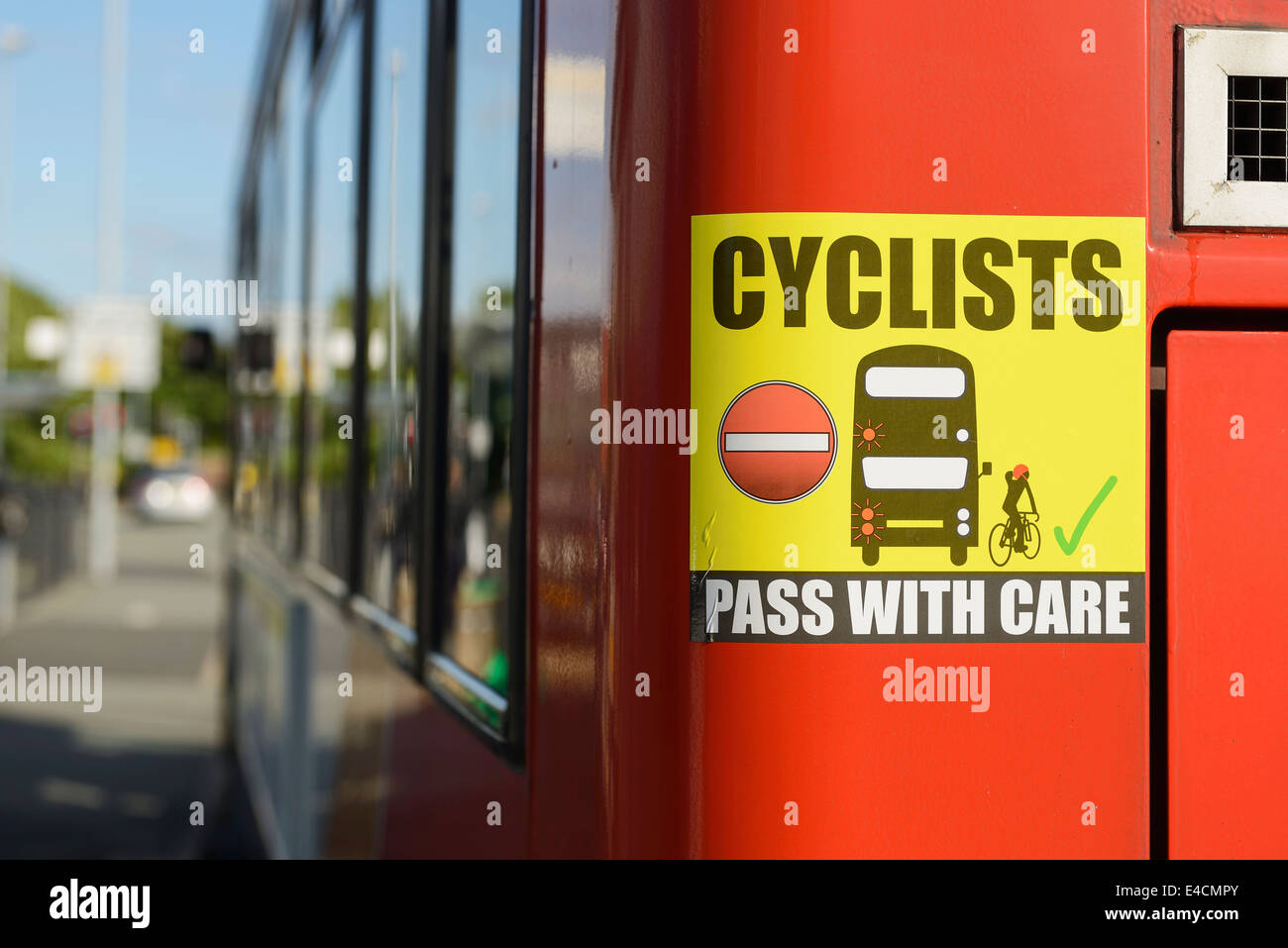 Radfahrer passieren mit Pflege-Zeichen auf der Rückseite eines Busses Stockfoto