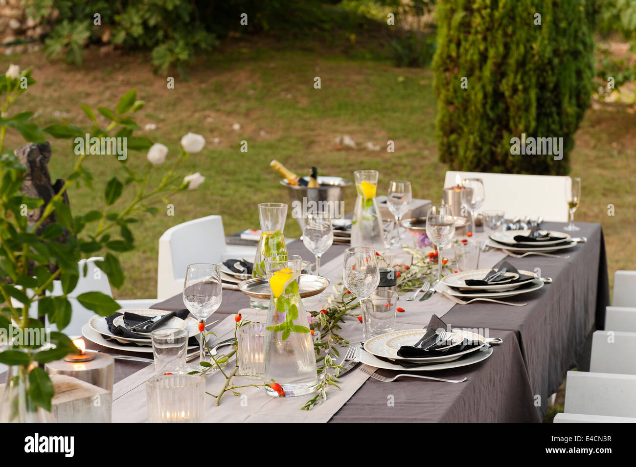 Ein Tisch im Freien für Abendessen und mit Hagebutten geschmückt. Die Stühle sind aus Le Pigeon d ' or Stockfoto