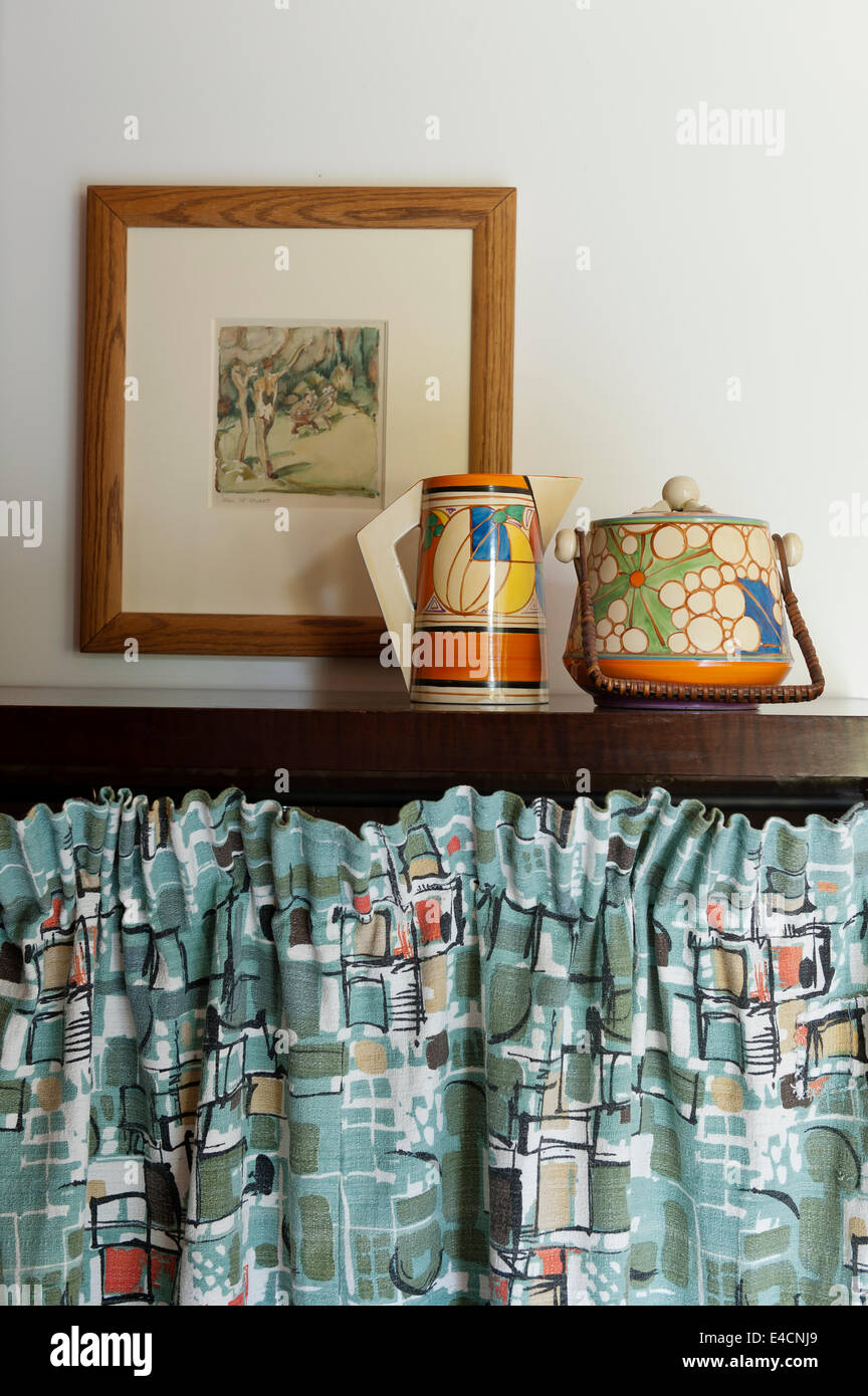 Clarice Cliff Krug und Teekanne auf Kommode mit Vintage-Baumwolle Vorhang Stockfoto