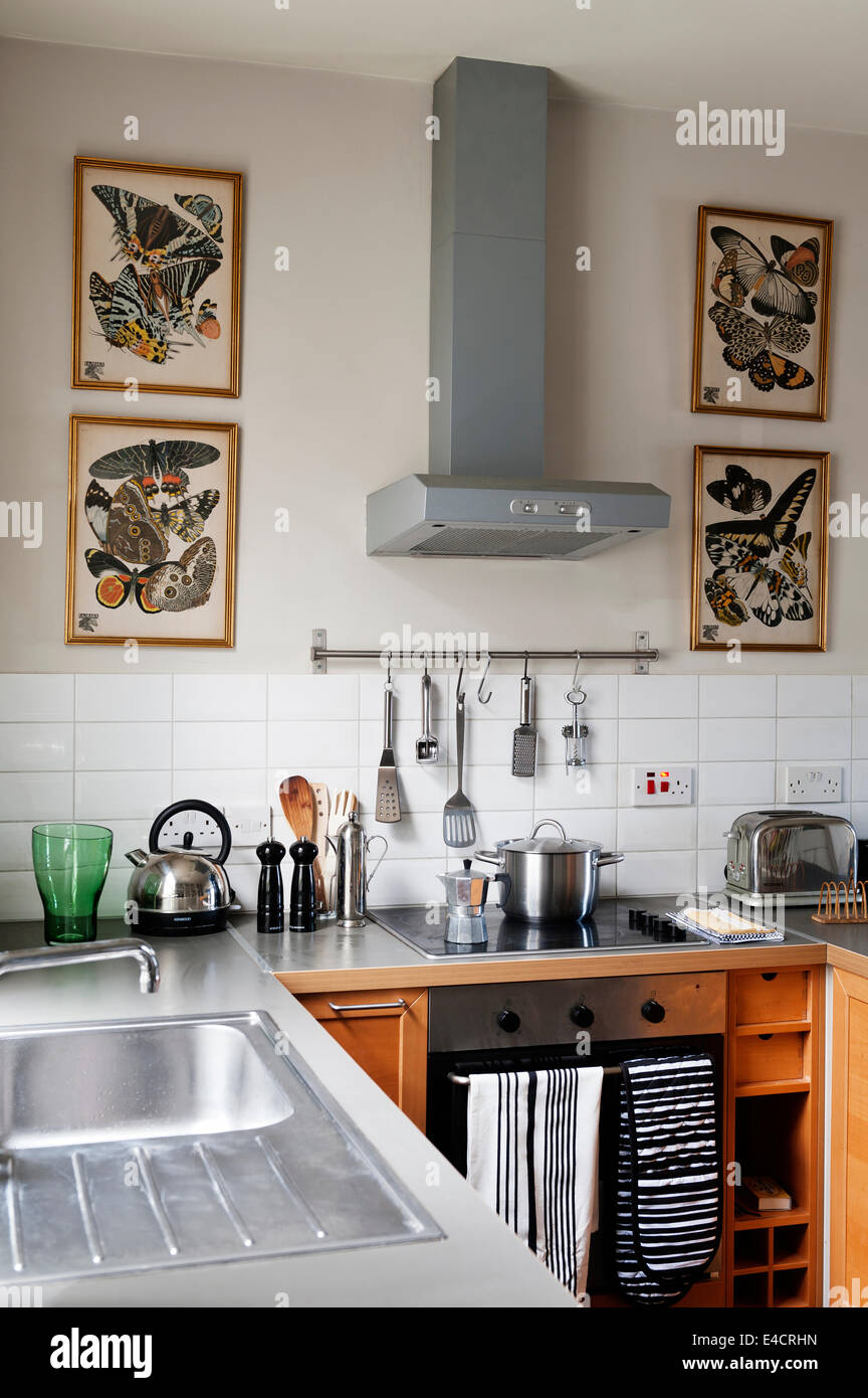 Vintage gerahmte Schmetterling druckt im Küchenbereich mit Metro-Fliesen von Fired Earth. Wand ist im Schiefer II durch die Farbe Librar gemalt. Stockfoto