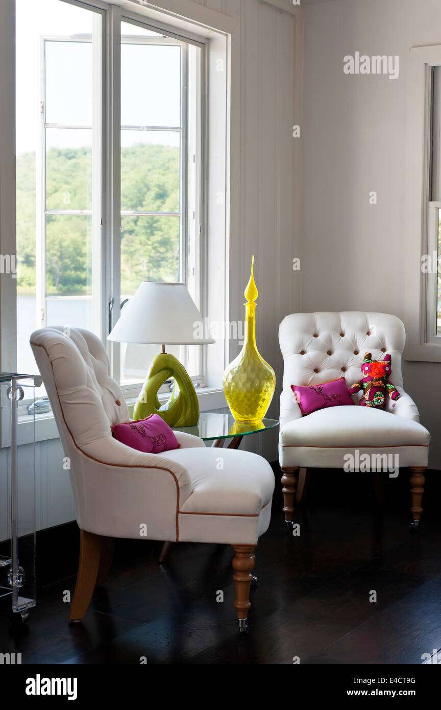 Paar geknöpfte Sessel in der Ecke des weißen Raum mit gelben Glasvase und Lampe Stockfoto