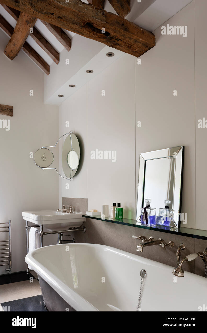 Roll Top Bad im weißen Badezimmer mit Holzbalken Stockfoto