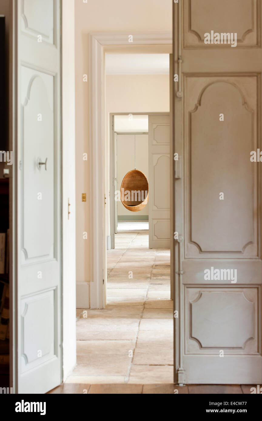 Blick durch mehrere offene provenzalischen Stiltüren Korbweide Pod Hängesessel Stockfoto