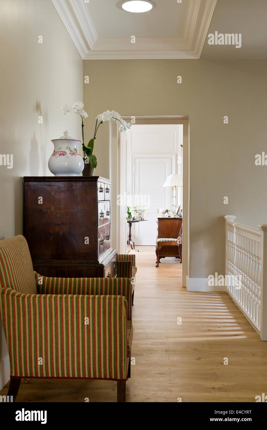 Große Holzkiste bei der Landung, flankiert von ein paar gestreifte Sessel Stockfoto