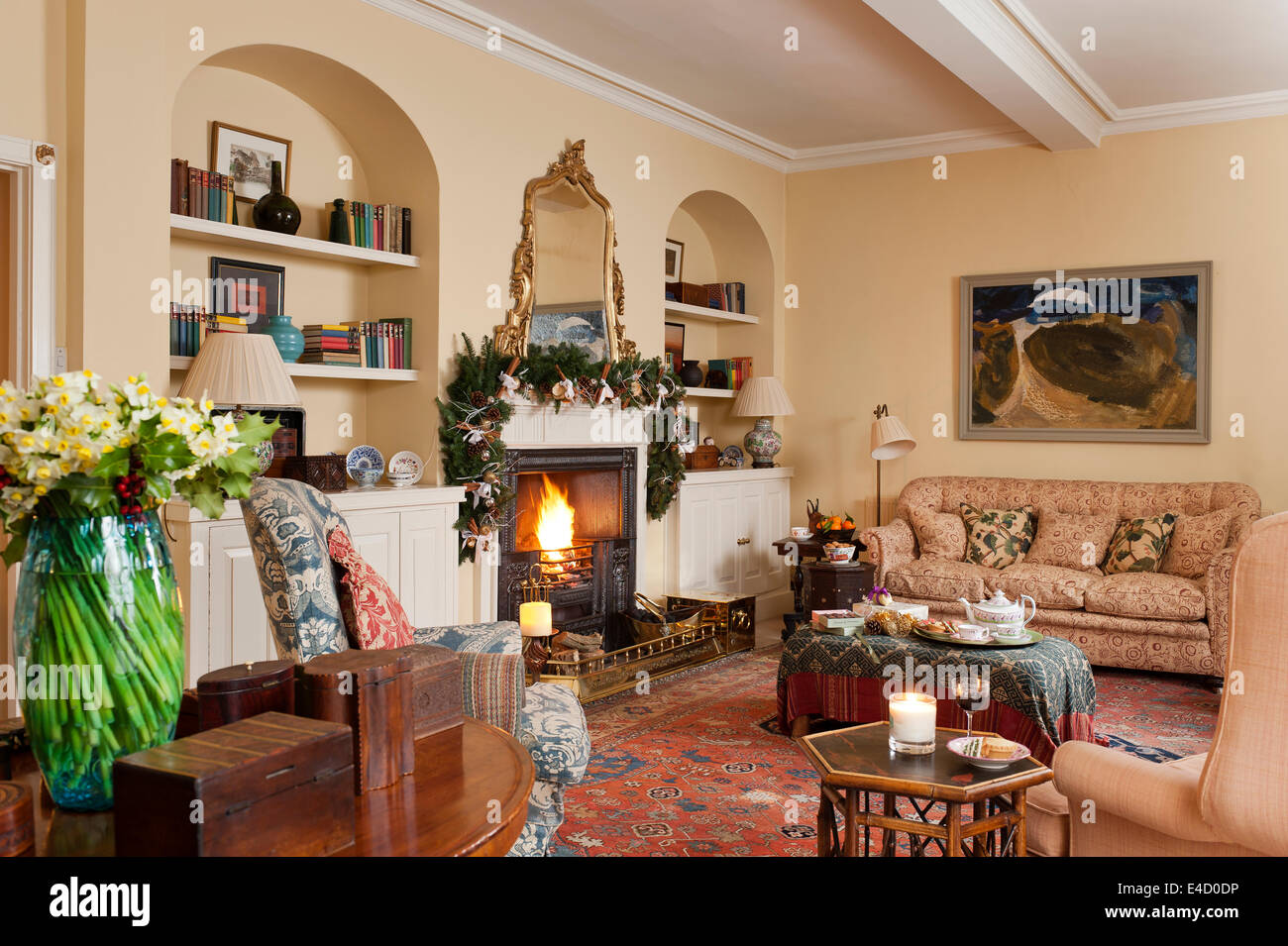 Gemütliches Wohnzimmer mit Kamin und verschiedene antike Möbel. Das Sofa ist Anfang des 19. Jahrhunderts und in Bennison Linie gepolstert Stockfoto