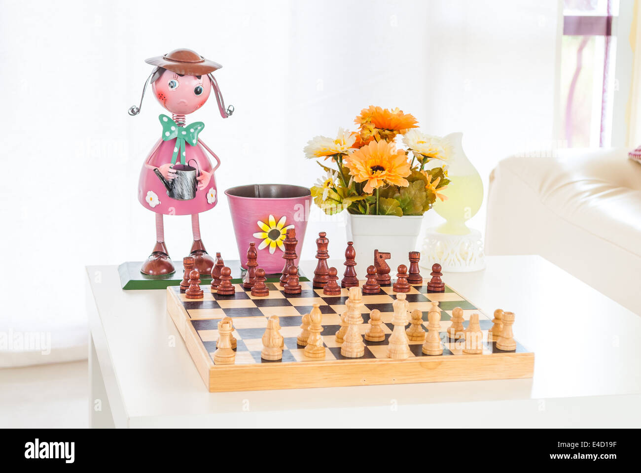 Schach mit Puppe und Blumen auf den Tisch. Stockfoto