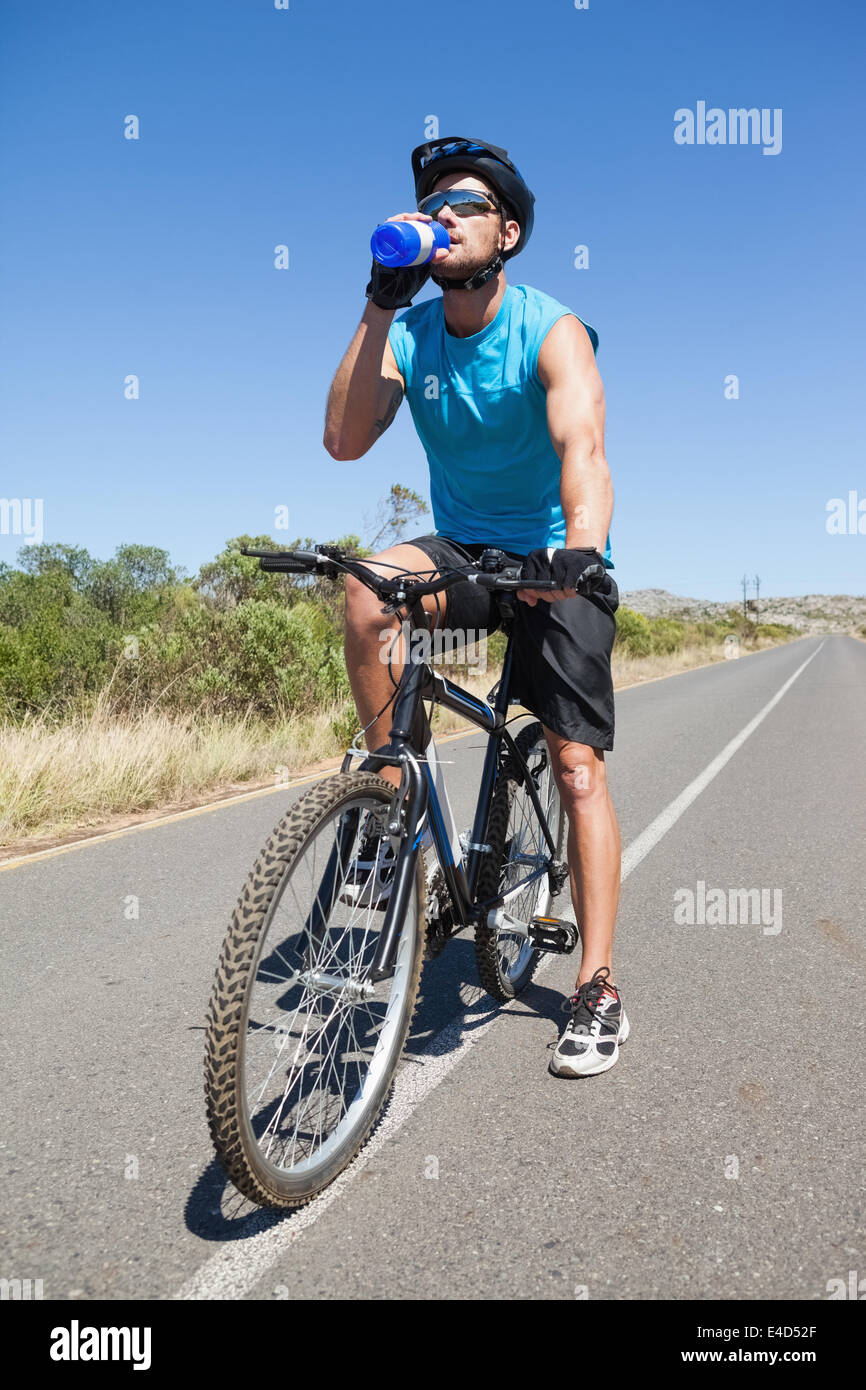 Gut aussehend Radfahrer eine Pause auf seinem Fahrrad-Trinkwasser Stockfoto