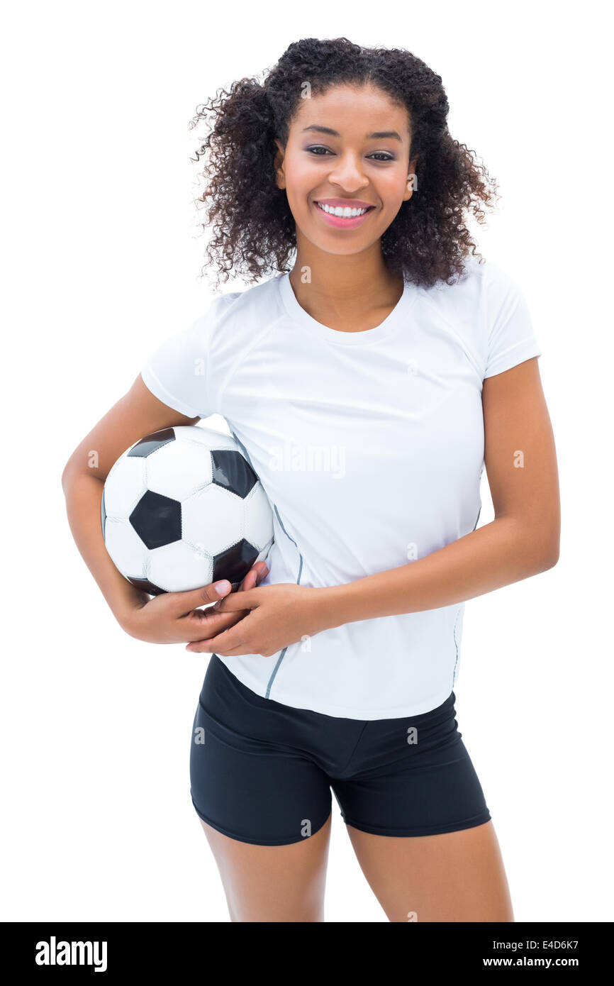 Hübsche Fußballspieler im weißen Holding Ball lächelt in die Kamera Stockfoto