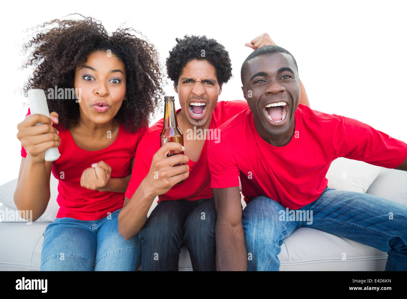 Fußball-Fans in rot Jubel auf dem Sofa mit Bier Stockfoto