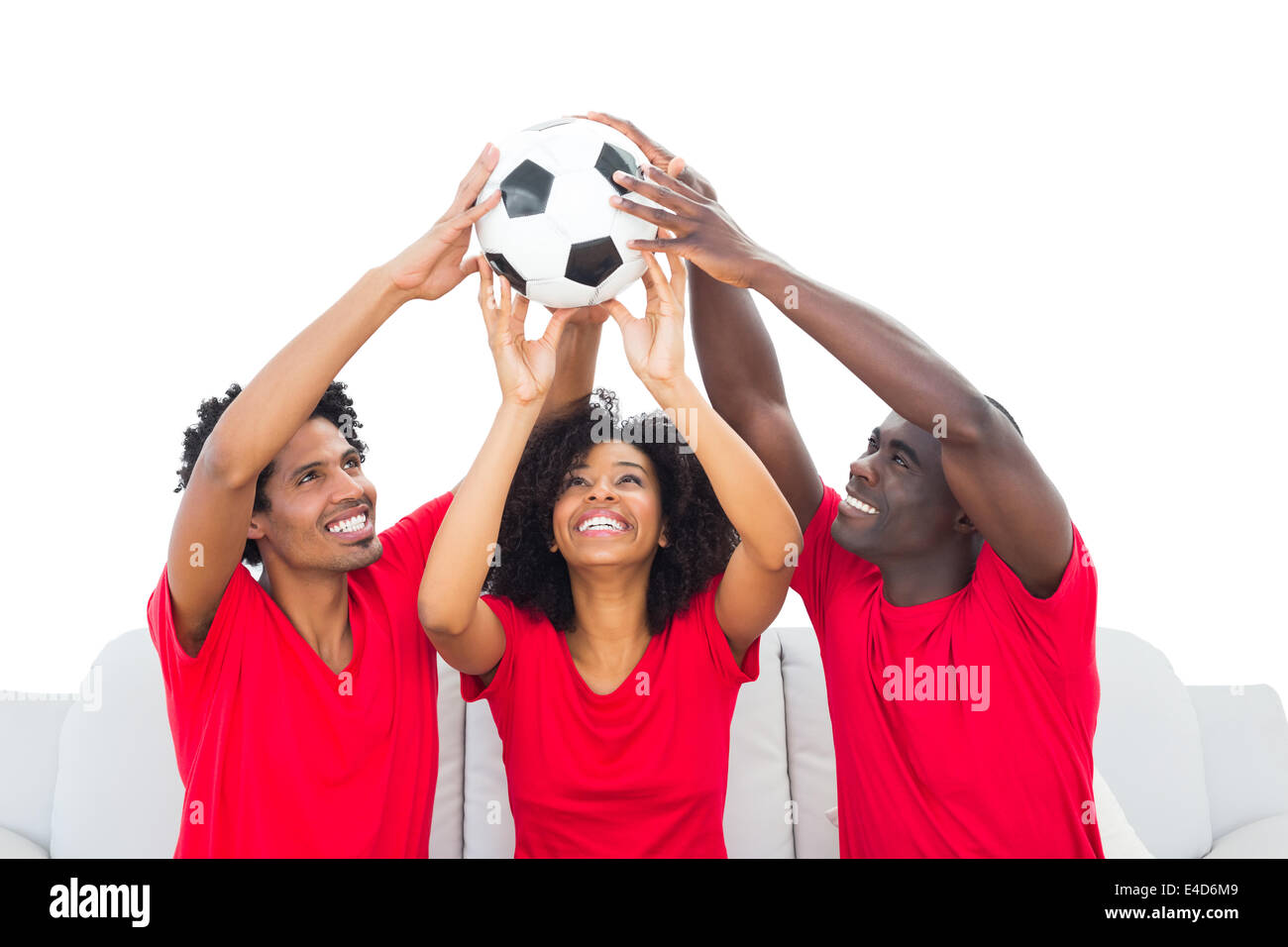 Glückliche Fußballfans in roten Ball hochhalten Stockfoto