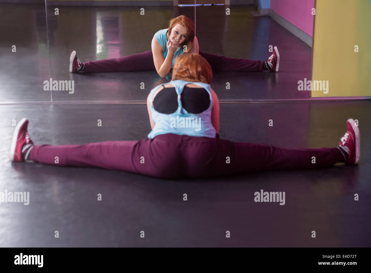Hübsche Pause Tänzer machen den Spagat in Spiegel Stockfoto