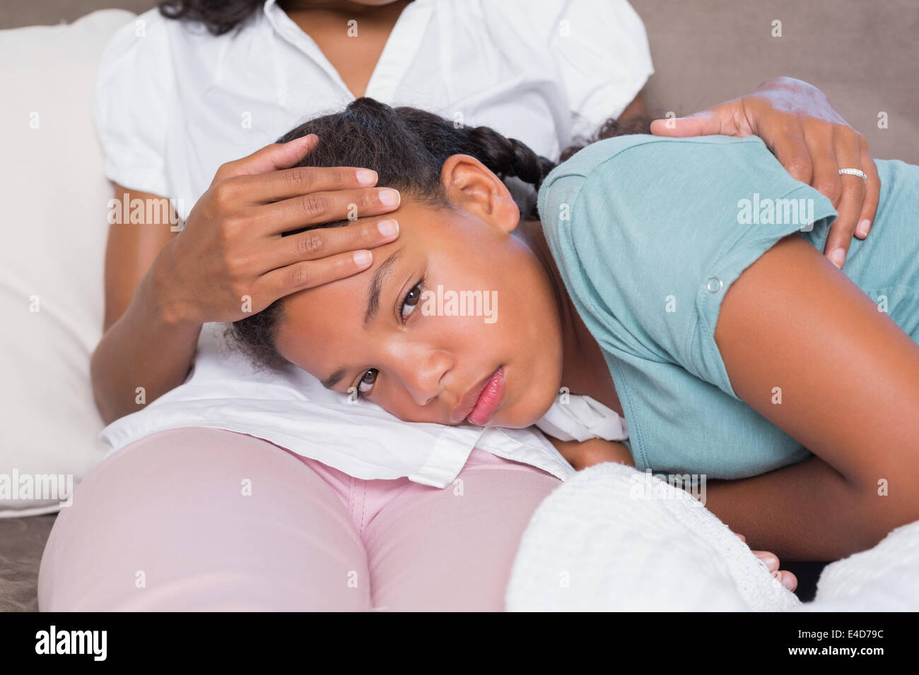 Kranke Tochter auf Mütter Schoß liegend Stockfoto